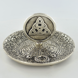 Silver coloured metal incense plate featuring a celtic symbol